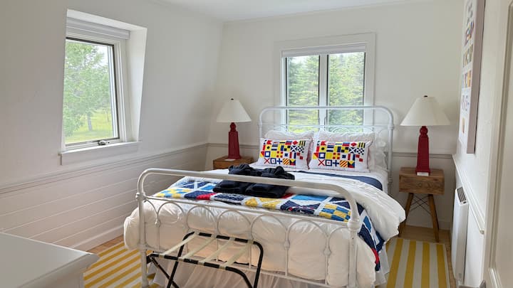 La chambre du drapeau nautique a un lit queen size, une commode et un placard.