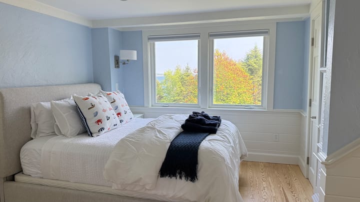 La chambre principale est située juste à côté de la cuisine.  Descendez trois marches et profitez de votre chambre avec vue sur l'océan, salle de bain attenante et espace de travail.