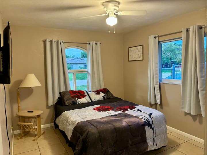 Dormitorio de invitados con televisión inteligente y cama de matrimonio.