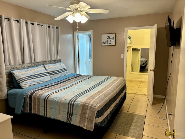 Dormitorio principal con cama tamaño king, vestidor y televisión inteligente.