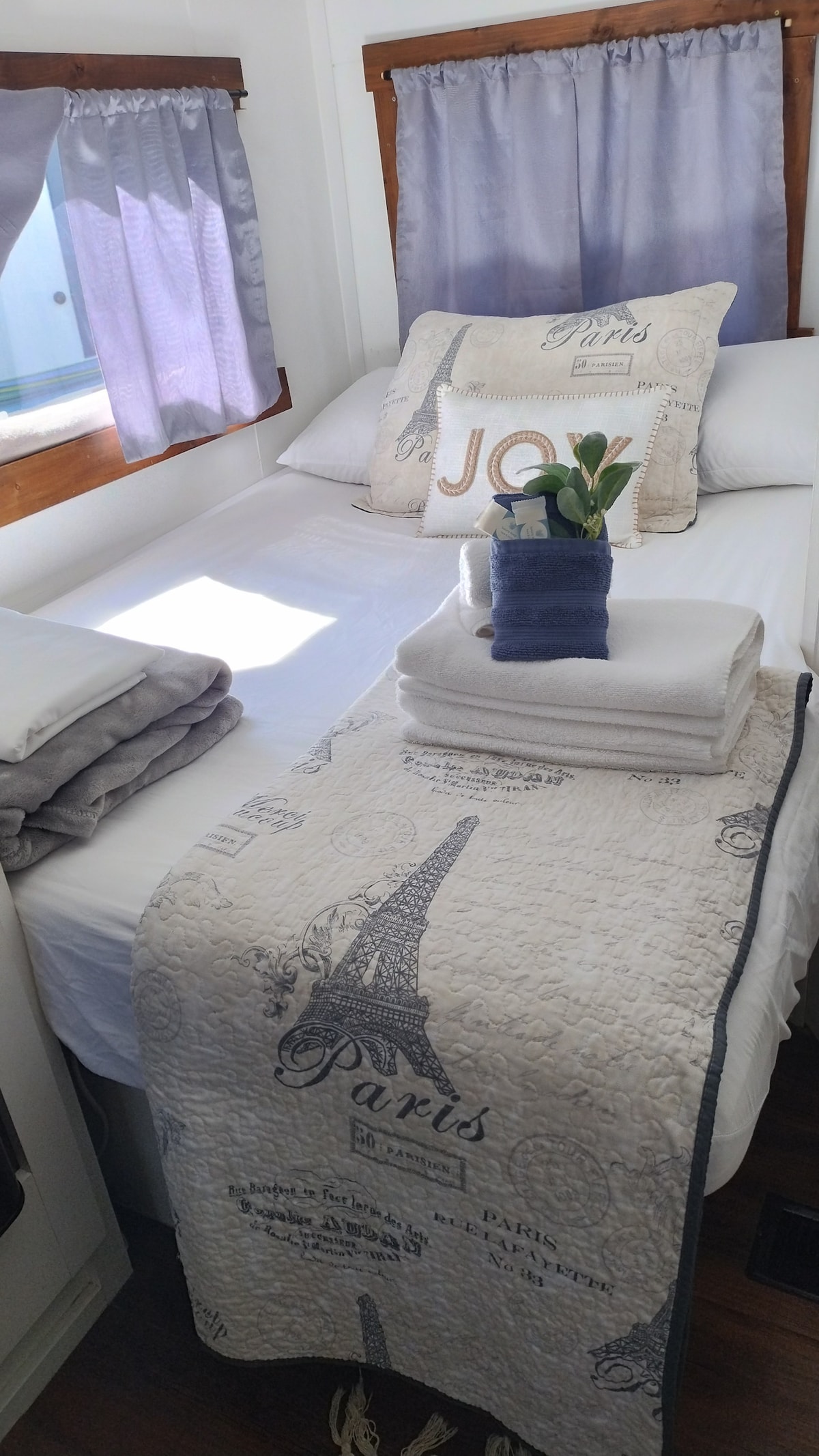 เตียงคู่พร้อมผ้าห่ม หมอน และสิ่งของจำเป็นอื่นๆ เพื่อการนอนหลับที่สะดวกสบาย