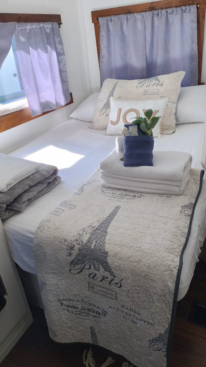 Manželská posteľ s ďalšími prikrývkami, vankúšmi a všetkými základnými potrebami pre pohodlný nočný odpočinok.