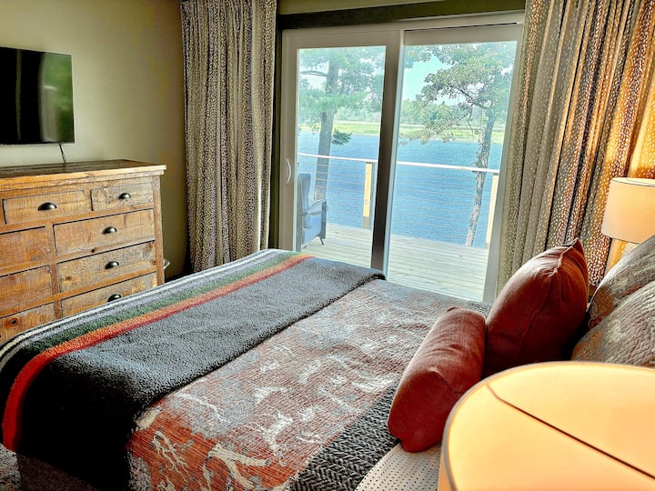 This queen bedroom opens to the lakeside deck through sliding doors and includes a new 32” smart TV and a ceiling fan with remote. Simple comforts in a peaceful setting.