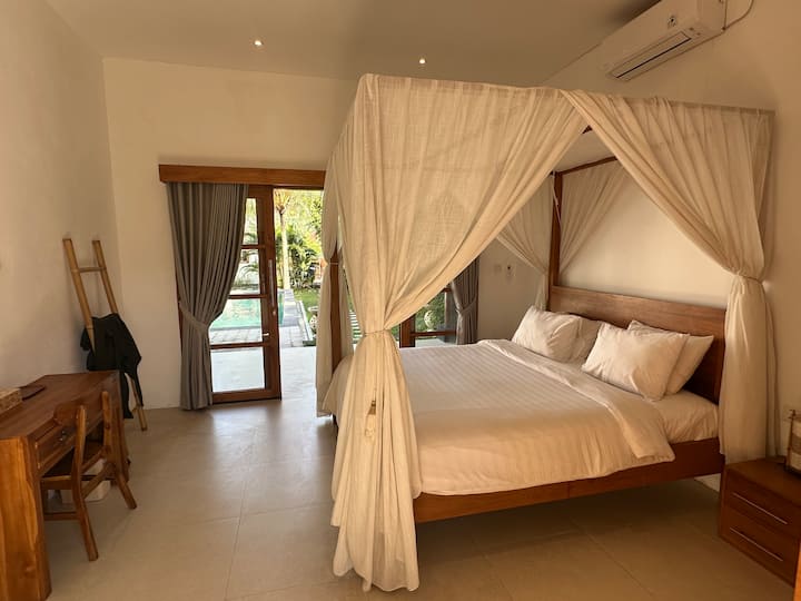 Spacious bedroom featuring mosquito nets and a comfortable queen-size bed.