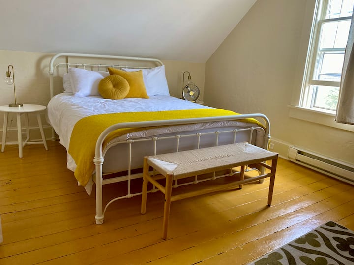 Une chambre spacieuse avec un lit queen et une porte Jack et Jill donnant sur la salle de bain.