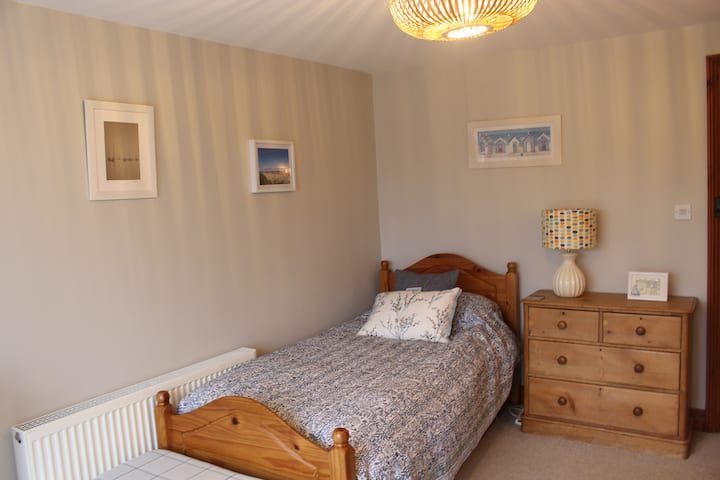 Spacious downstairs  single bedroom with chest of drawers. 
Also a desk if you need to catch up on any work in a quiet space away from family life.