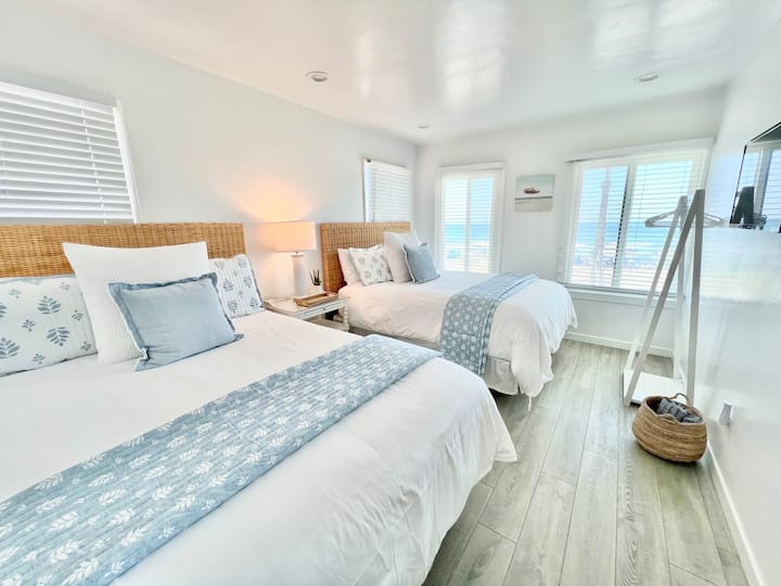 "ห้องนอนชั้นบนมีวิวทะเล เตียงควีนไซส์หรูหรา ผ้าปูที่นอนนุ่มๆ และการตกแต่งสไตล์ชายฝั่งที่สงบ เหมาะสำหรับการพักผ่อนหลังการผจญภัยที่ชายหาด"