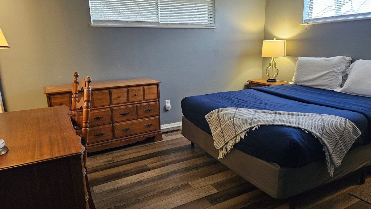 Dormitorio principal con cama tamaño queen, escritorio, vestidor, lámparas de noche y ventana para luz natural.
