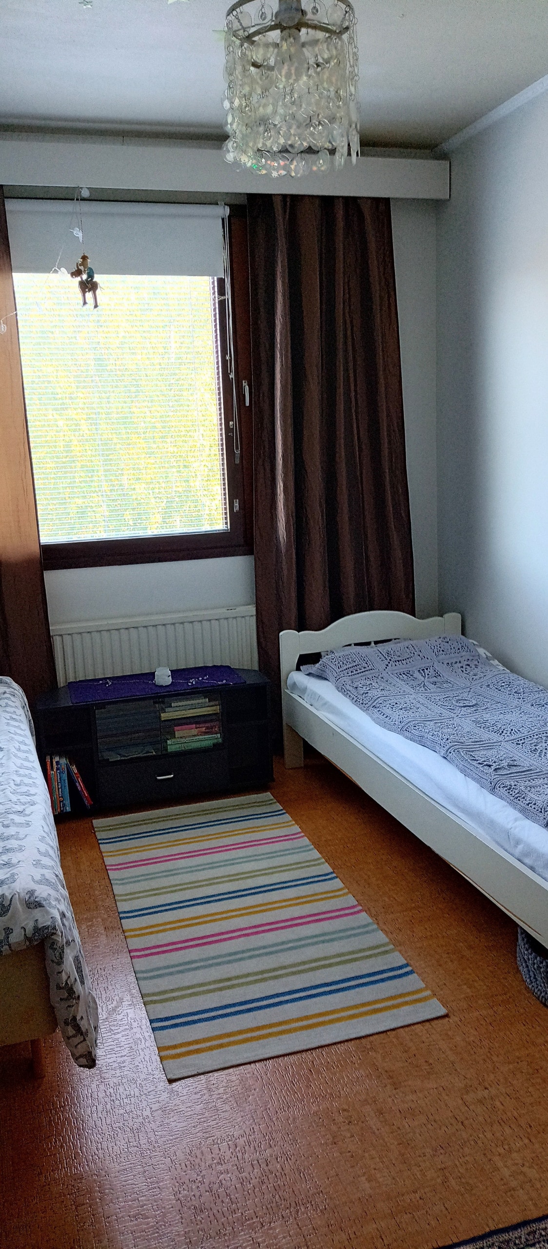 في غرفة النوم، سريران بعرض 80 سم وكتب وألعاب.