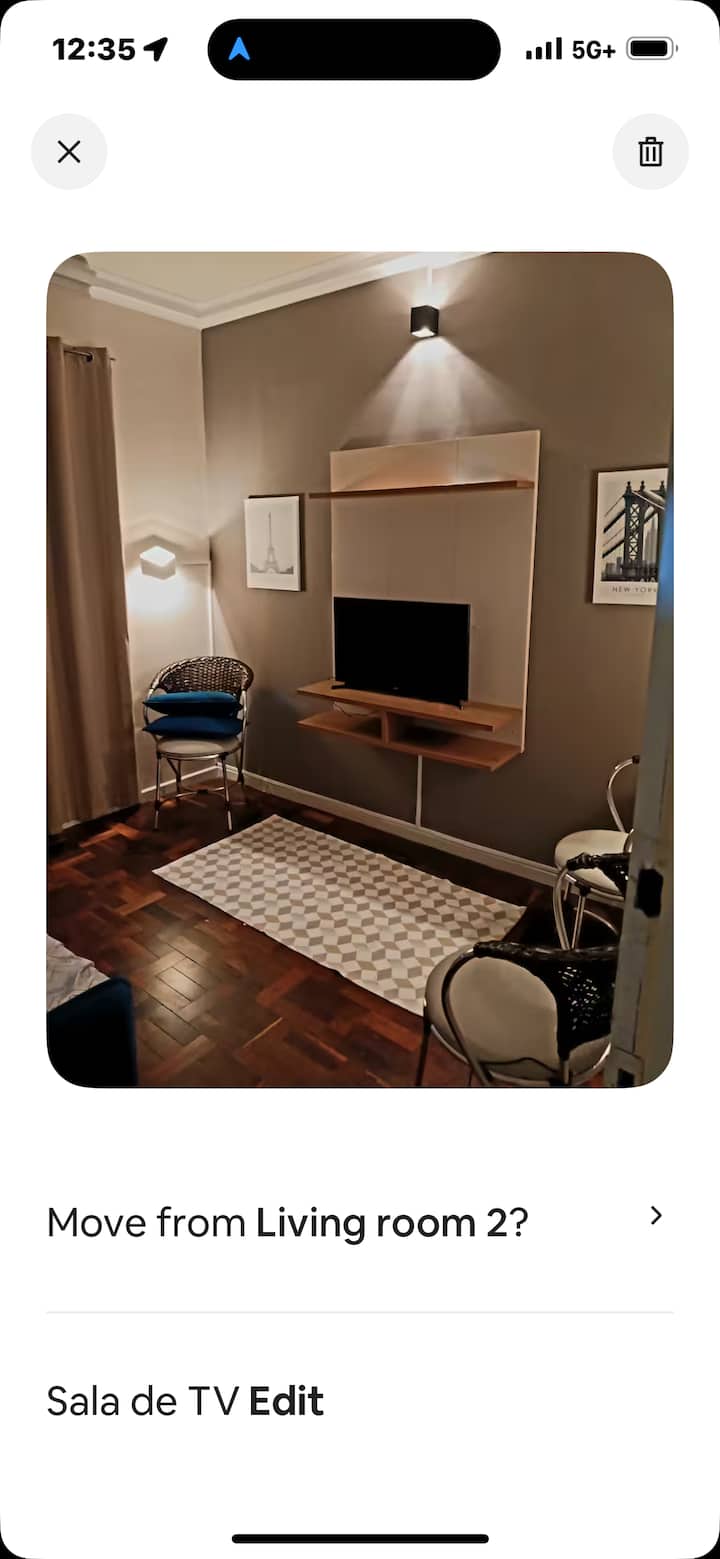 Esta es una sala de televisión con un sofá y una cama individual.