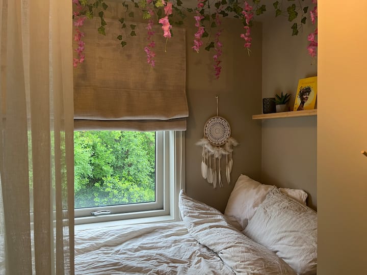 Mala udobna soba s ugrađenim krevetom i zavjesom ispred. Na zidu i ormaru nalazi se veliko ogledalo. 