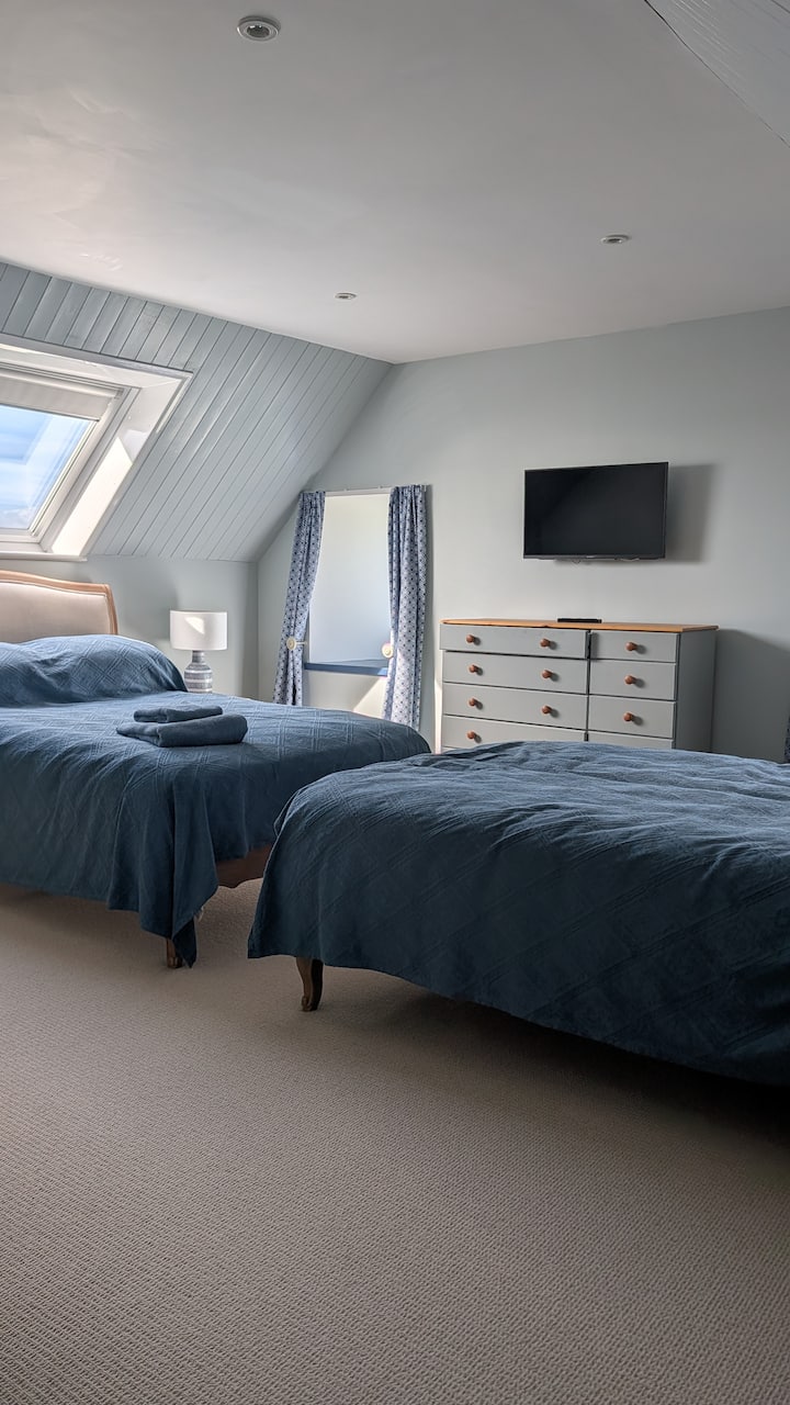Blue Double/Twin bedroom. Two double beds. One double sofa. Wardrobe. One large chest of drawers. Smart TV. Seaviews and countryside views (Top floor). 