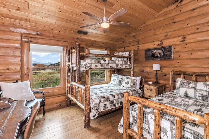 Una cama doble y una litera doble sobre queen en el loft, con hermosas vistas de la Grand Mesa a través de las ventanas.