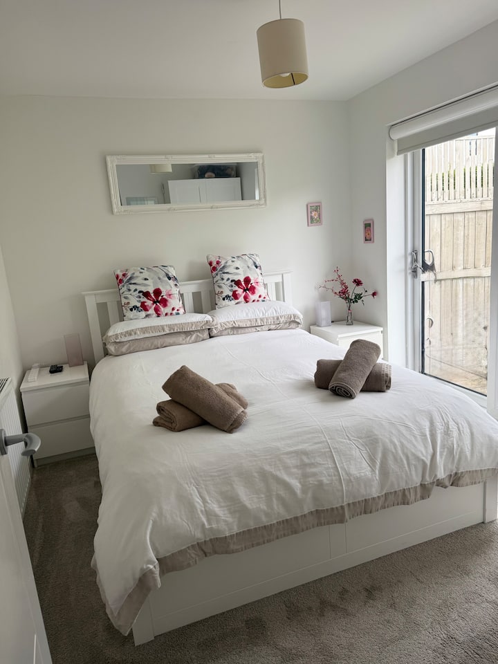 Spavaća soba s bračnim krevetom (king size) u prizemlju nasuprot spavaće sobe s krevetom na kat. Električne žaluzine za zamračivanje. Klizna vrata na terasi koja vode u zatvoreni stražnji vrt. TV i Fire Stick. 