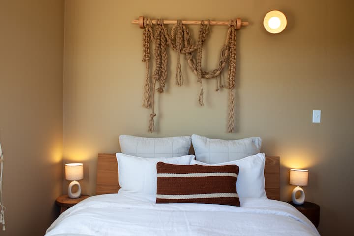 One queen size bed with linen bedding.