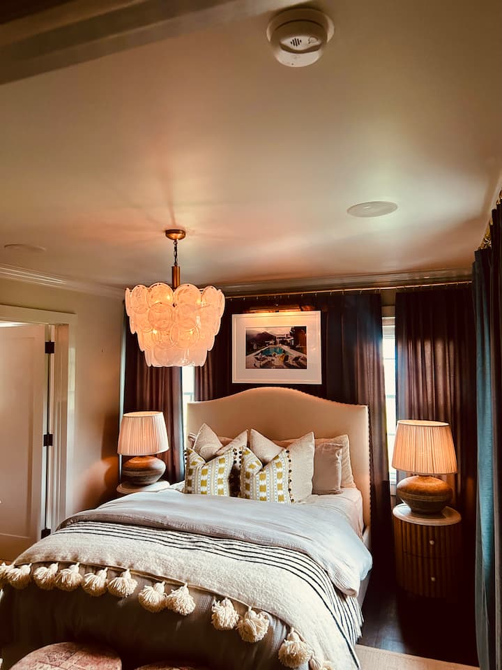 غرفة نوم رئيسية مريحة مع مكبرات صوت مدمجة وتصميم أنيق. 