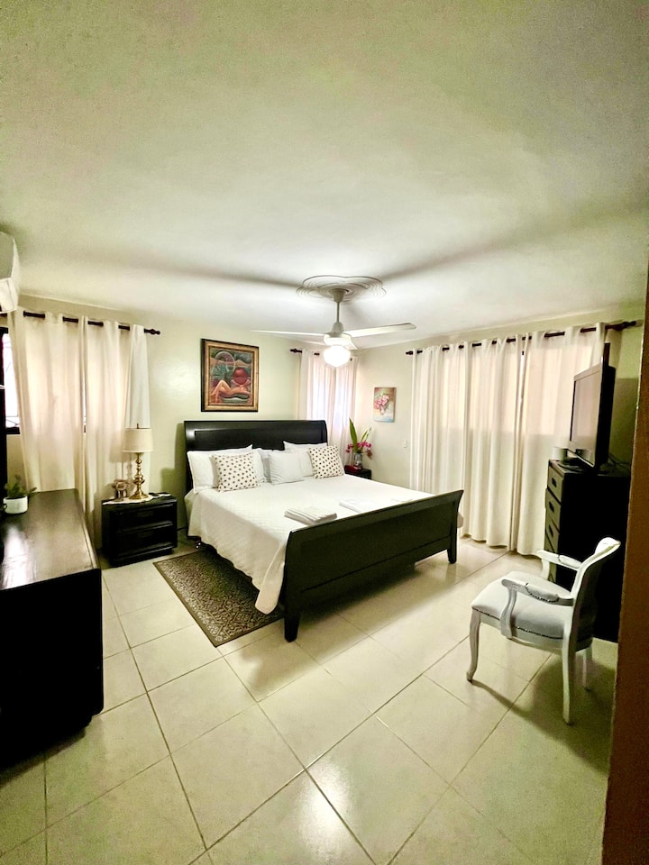 宽敞的主卧室，配备独立卫生间、电视、空调