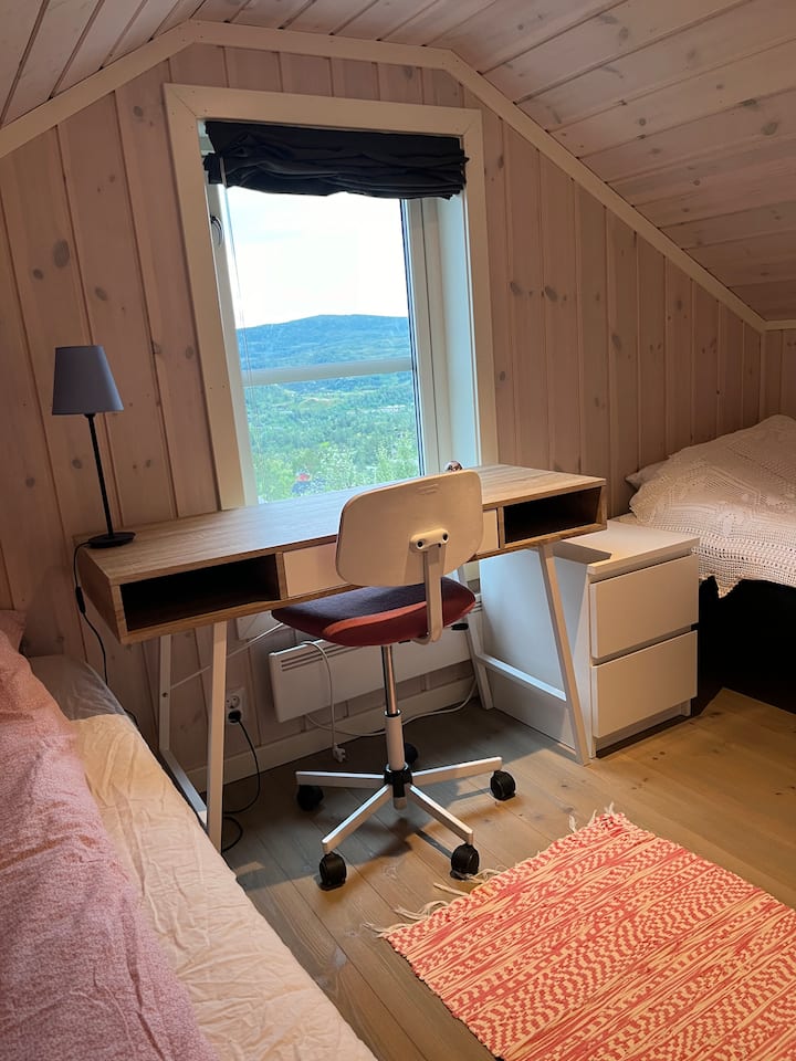 Área para dormir con 2 camas individuales y escritorio