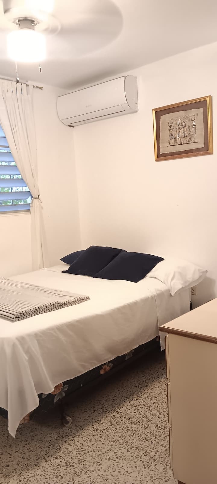 Cama completa con aire acondicionado, ventilador de techo y armario con espejo corredizo.