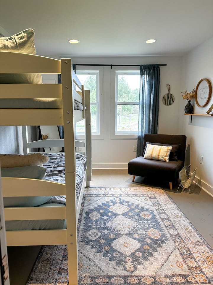 第三间卧室可俯瞰花园，包括带折叠椅的双层床，可供额外的休闲/睡眠选择。 