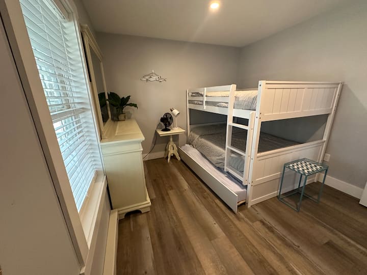 Lits superposés complets, lit gigogne double en bas, grand bureau, placard et ventilateur.