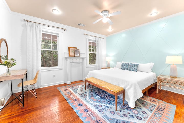 Habitación #1 Habitación con jardín: la habitación más espaciosa de arriba, con una cama tamaño king y una acogedora zona de escritorio tropical. Esta habitación se ducha con luz solar durante el día y da al patio trasero. Hay persianas que bloquean la luz para una noche de sueño tranquilo.