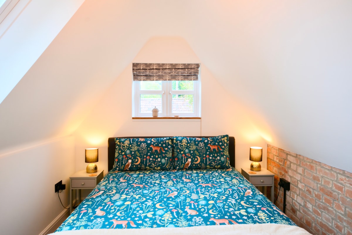 La cama tamaño king es el punto focal con un tema de bosque. La habitación cuenta con iluminación suave y persianas opacas.
La gran ventana tiene vistas a los árboles, lo que aporta la belleza del exterior.
Las comodidades modernas incluyen puertos USB.