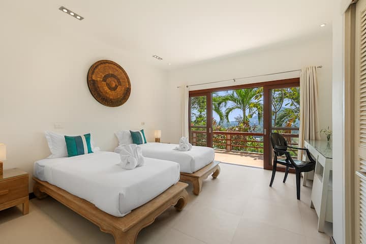 Despierta con la suave luz matutina en un elegante dormitorio de la villa con camas individuales para un sueño tranquilo. Experimenta el lujo con un diseño práctico para una estadía tranquila.