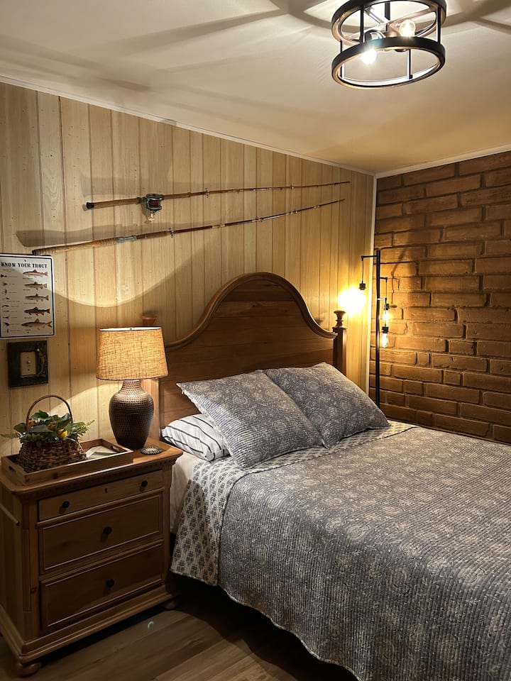 سرير بحجم متوسط مع طاولة جانبية ومقابس للهواتف المحمولة. 