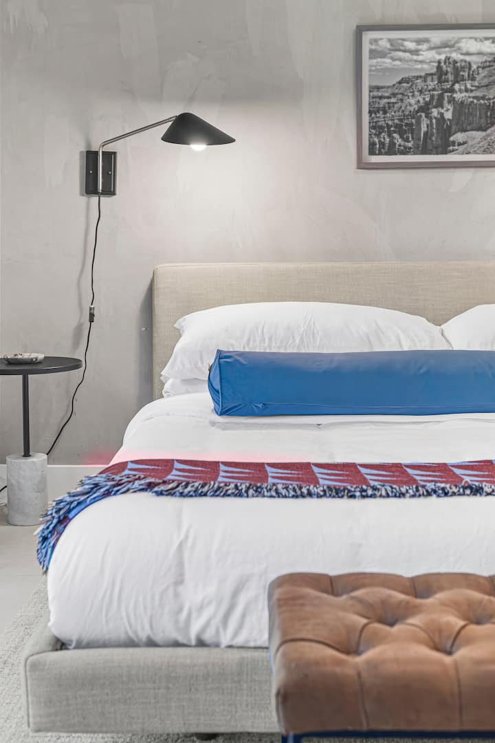 La chambre principale est dotée de draps propres et de couleurs gaies partout. Des portes coulissantes en verre s'ouvrent sur le jardin.