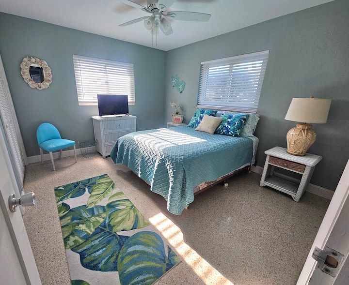 Dormitorio grande con cama queen, tocador, armarios y televisor