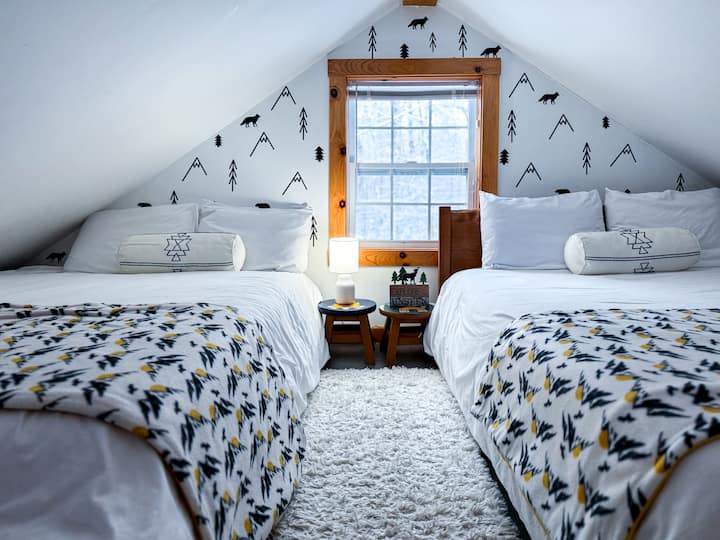 The playful loft has two queen beds and overlooks the living room. Enjoy peaceful views of the wooded backyard - perfect for taking in the cabin’s calm and quiet setting.