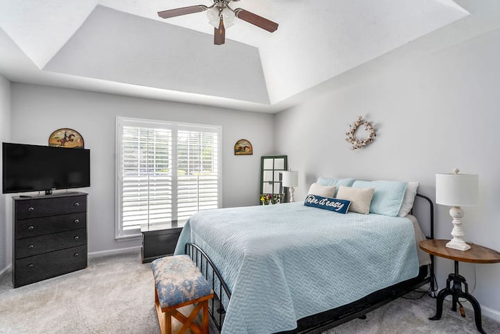 The primary bedroom is spacious with a comfy queen bed, Roku TV, and attached private bathroom and walk-in closet.