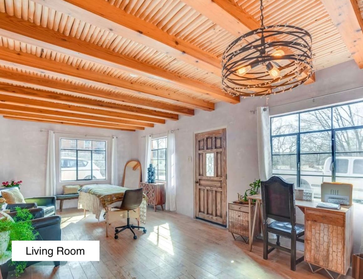 Living room with seating for 2, work desk, and open floor space for self-care and wellness. Can book table massage, mediumship, or intuitive services in town to come to the house. 