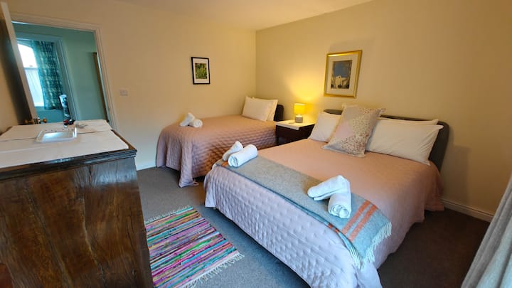 Driepersoonskamer met een kingsize bed en een eenpersoonsbed.  Prachtig uitzicht over de velden en naar het kasteelterrein.  Antieke ladekast.