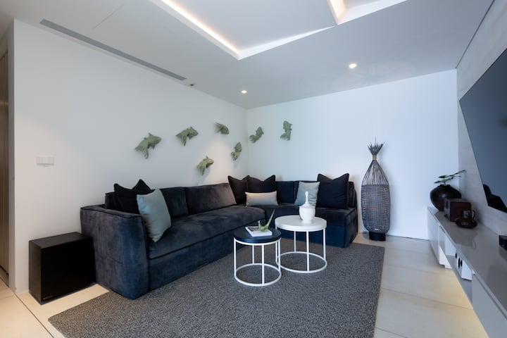 Sala multimedia relajada con asientos modulares y TV montada en la pared
