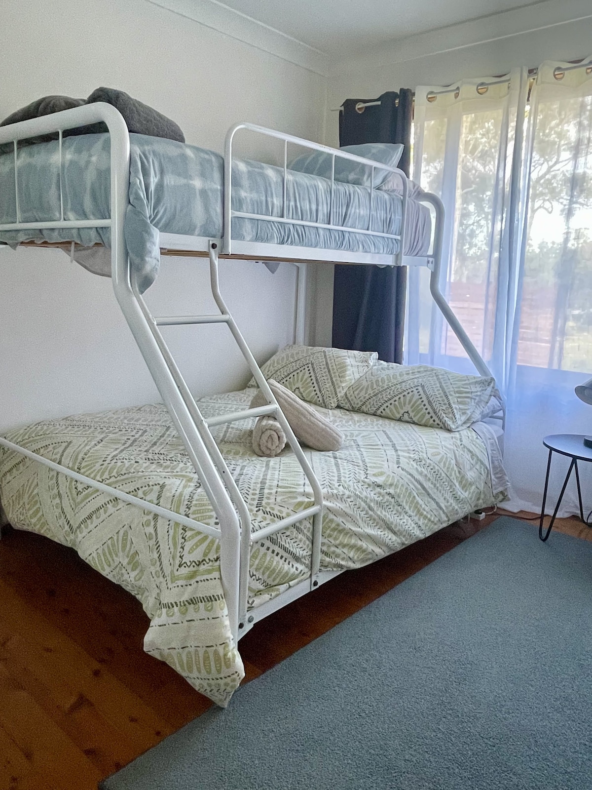 Kitanda cha ghorofa chenye kitanda kimoja juu na kitanda cha watu wawili chini.