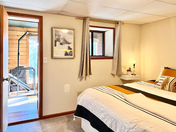 Kuangalia chumba cha matope/eneo la mazoezi ya viungo kuanzia chumba cha kulala. Chumba cha kulala ni cheusi sana huku milango na mapazia yote yakifungwa 