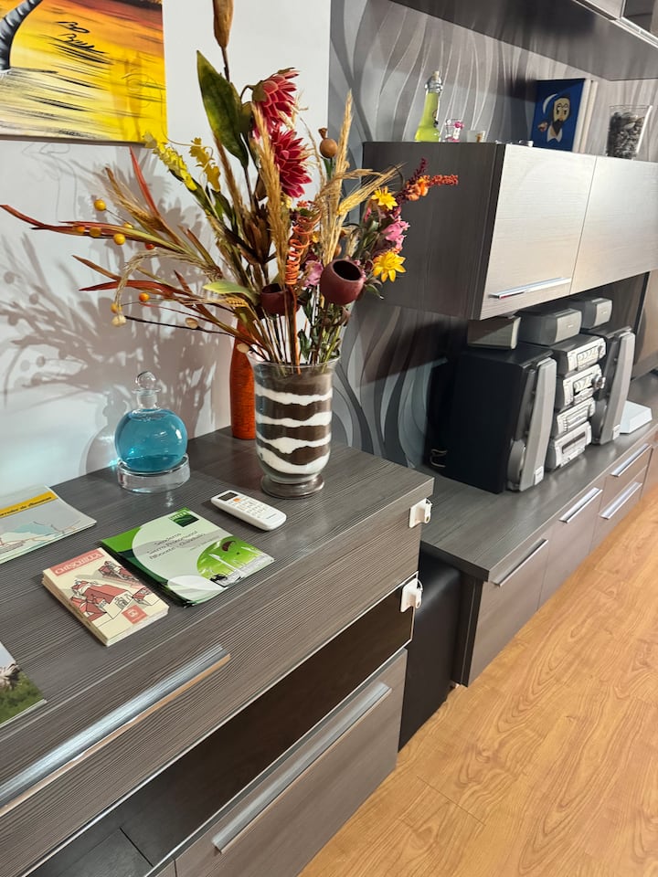 Mueble del salón con equipo de música y detalles cuidados para sentirte como en casa.