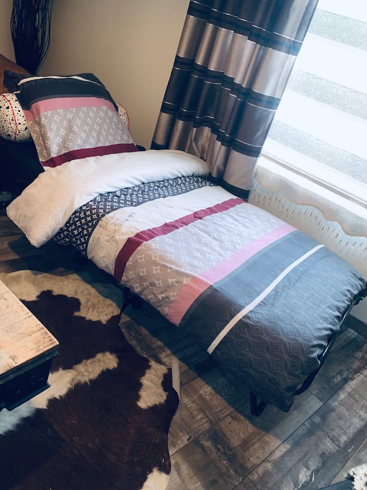 เตียงพับสำหรับ 1 คนในห้องนั่งเล่นของบ้าน