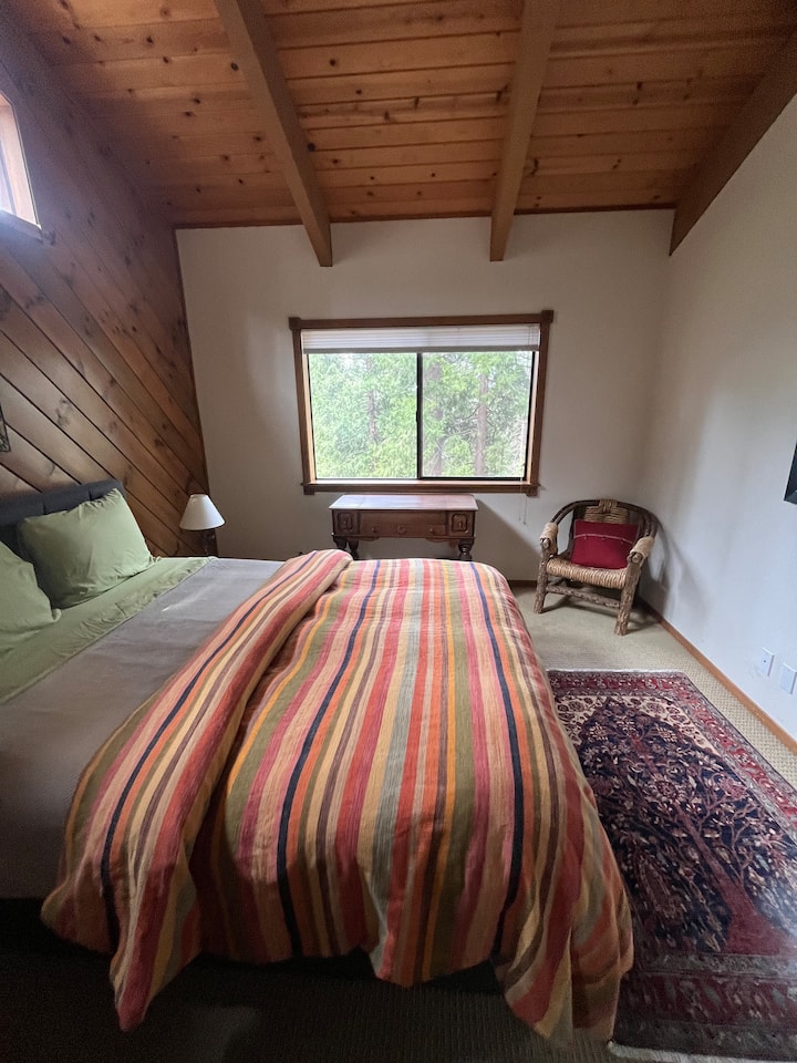 ¡Cómoda cama tamaño queen en el dormitorio de invitados con hermosas vistas al bosque!