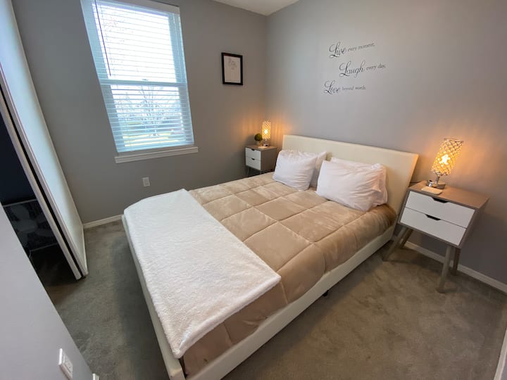 Habitación blanca con cama de plataforma.
