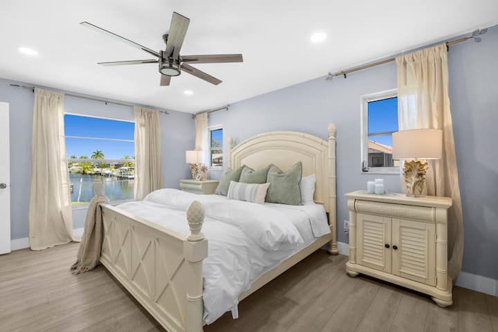 Relájese en el amplio dormitorio principal, que cuenta con una cama tamaño king con ropa de cama de lujo y colchón de espuma viscoelástica, amplios ventanales luminosos con apacibles vistas al mar y un televisor de pantalla plana para disfrutar de noches relajantes en un tranquilo refugio costero.