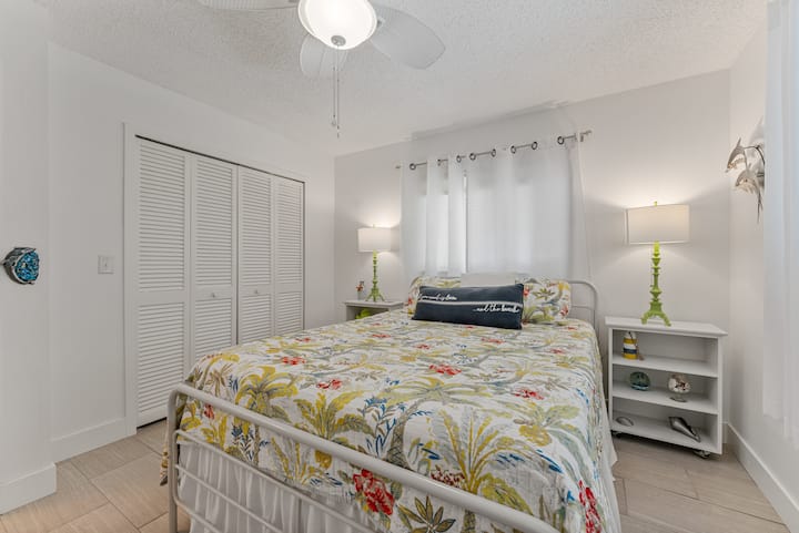 Habitación de invitados luminosa con ropa de cama acogedora y espacio en el armario.
