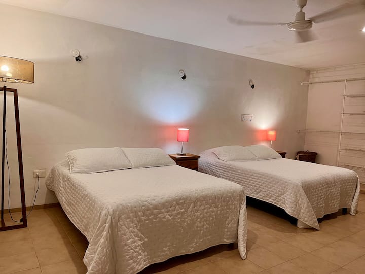 Guest room with two queen-size beds, smart TV, and a desk!