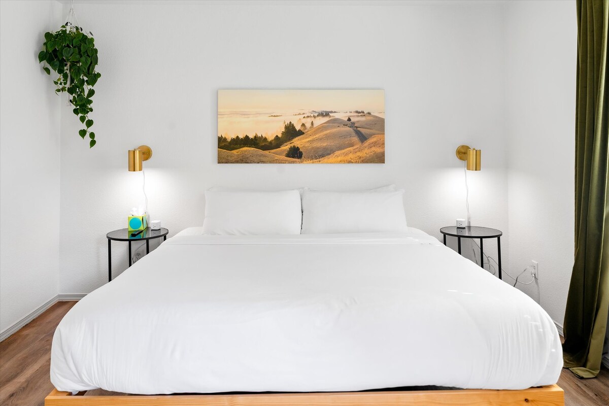 Amplio dormitorio con cama tamaño «king», cortinas opacas y acceso al baño privado.