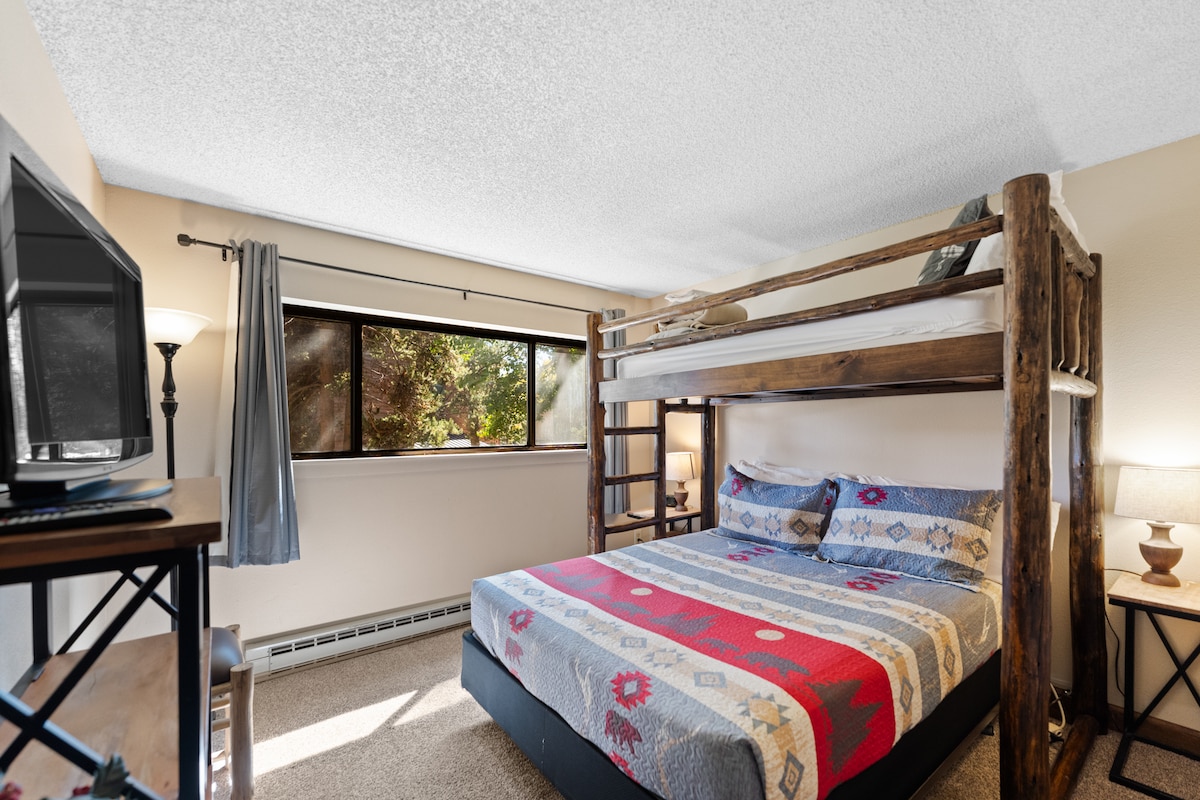 Guest bedroom with a twin-over queen bunk bed and flat screen TV.