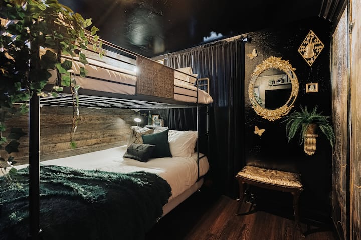 Behind our speakeasy bookshelf lies our secret bedroom with plush Queen memory foam bunk beds, a twin trundle bed option below, and a Pac-Man 12-in-1 arcade! A cozy, hidden retreat inspired by the charm of Old Hollywood!