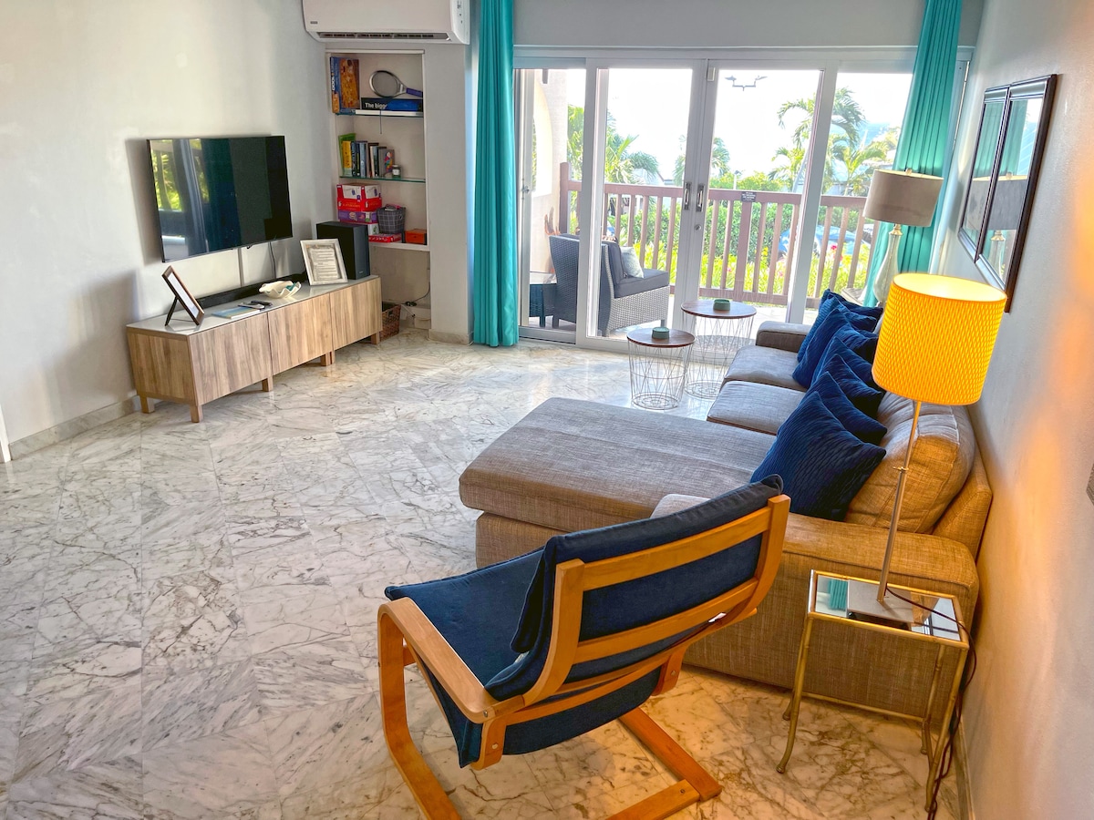 明亮的起居区，配备全套空调、电视、音响系统和阳台通道