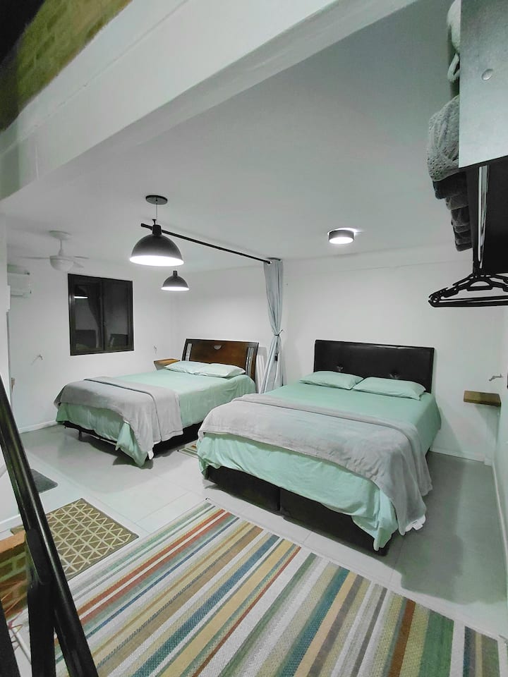 Segundo piso: suite abierta, con 2 camas tamaño queen, aire acondicionado frío/calor de 12 000 BTU, ventilador de techo y baño.